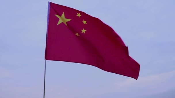 Schwenkt die chinesische Flagge. Flagge der Volksrepublik China gegen den blauen Himmel. — Stockvideo