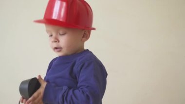 Genç Sevimli Oluşturucusu çocuk tek tip ve sabit hat veya kask ile inşaat ve onarım arka planı Elektrikli tornavida.