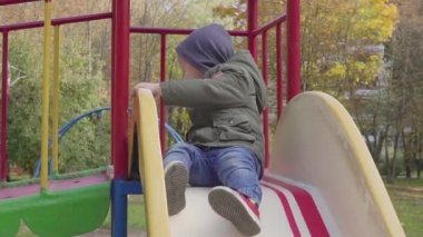 Neşeli çocuk oyun parkında tepeden aşağı sürme