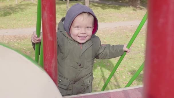 Glada Pojken klättrar stairse på lekplats — Stockvideo