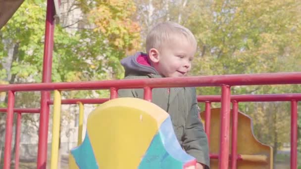 Fröhlicher Junge läuft auf Brücke auf Spielplatz — Stockvideo