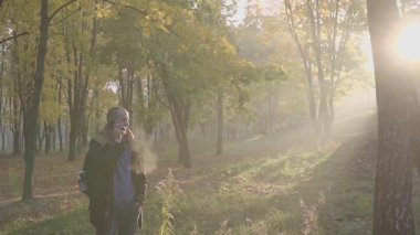 Sonbahar parkta konuşan telefon mobil yakışıklı sakallı genç adam