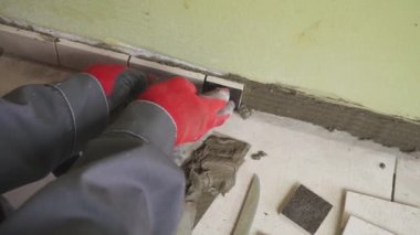 Çalışan küçük fayans mutfak duvar ayarlar. Elleri döşeme üzerinde yapışkan yerleştirir. çekim stedikam
