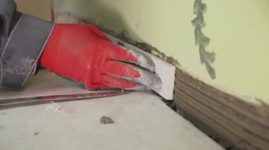 Çalışan küçük fayans mutfak duvar ayarlar. Elleri döşeme üzerinde yapışkan yerleştirir. çekim stedikam. portre