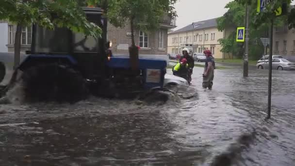 ミンスク。ベラルーシ - 21。05.2018: 市では、大雨の後の通りに殺到しました。救助避難ヨーロッパの都市で引込められた壊れた車. — ストック動画