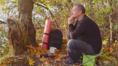 Bir gaz brülör üzerinde sonbahar ormanda pişirme. Turist pot gıdalardan çalışır.