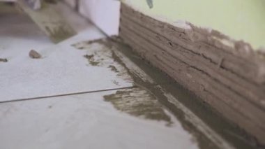 Çalışan küçük fayans mutfak duvar ayarlar. Elleri döşeme üzerinde yapışkan yerleştirir. çekim stedikam. portre