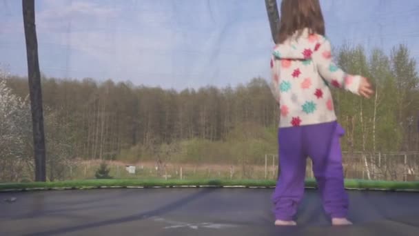 Ευτυχισμένος κορίτσι τριών ετών άλμα σε ένα τραμπολίνο. Συναισθηματική χαρούμενη πορτρέτο. Αργή κίνηση — Αρχείο Βίντεο