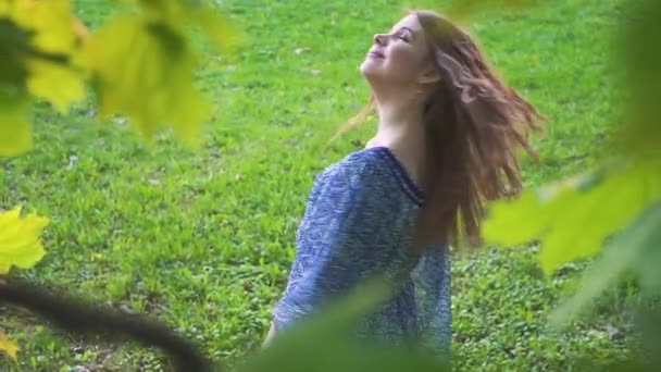 Aantrekkelijk meisje krullen haar in het park-closeup. — Stockvideo