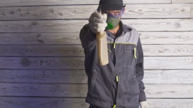 Bir şeyi temizlemeye hazır spreyli bir adamın portresi.