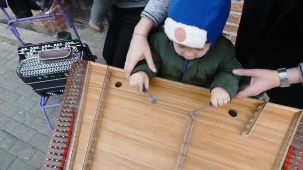 Baby spielt Becken im Freien. Straßenmusiker — Stockvideo
