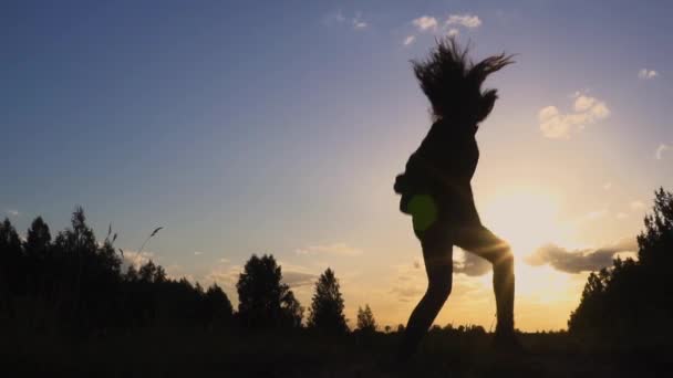 Silhouet van jonge vrouw springen op zonsondergang slow motion — Stockvideo