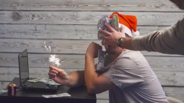 bengal ile Noel şapkalı bir rüya gibi adam ateş maytap ve laptop onun ellerinde. Düşen para dolar.