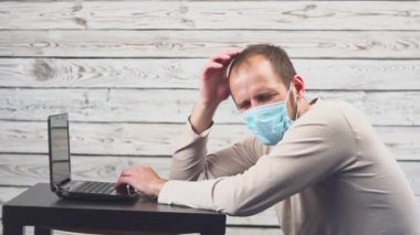 Hasta işadamı sıcaklık ve çalışma office baş ağrısı ile dizüstü bilgisayar kullanın. Öksürük ile yüz maskesi giyen adam.