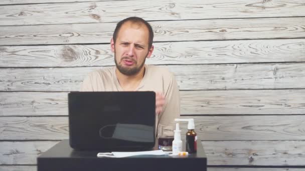生病的胡子男子咳嗽, 坐在工作场所与计算机. — 图库视频影像