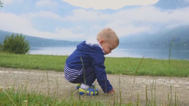 Küçük çocuk dağ göl kenarında yürüyor. Çalışan ve doğada eğlenirken. — Stok video