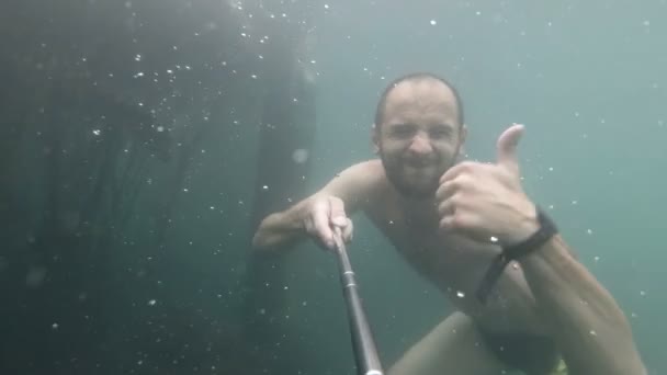 Unterwasserporträt eines lächelnden Mannes. Person, die Spaß im Schwimmbad. Sommerferienkonzept. selphi. — Stockvideo