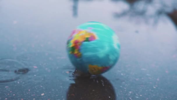 Planeet aarde mooie valt in een modderige plas. Concept inzake milieukwesties. Problemen van duurzame ontwikkeling. Slow motion. — Stockvideo