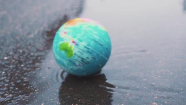 Planète terre belle tombe dans une flaque boueuse. Concept sur les questions environnementales. Problèmes de développement durable. Mouvement lent .