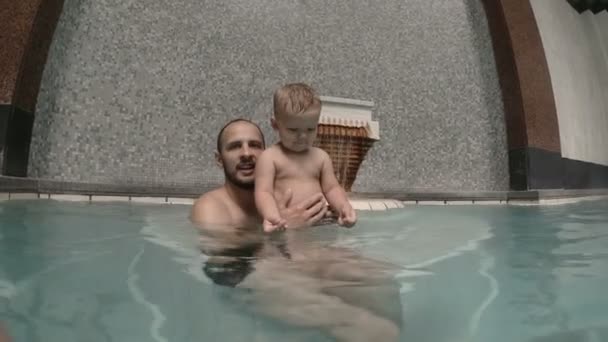 Bébé avec papa nageant dans la piscine. père et fils — Video