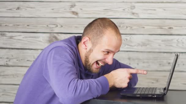 Hombre sonriente sentado en la oficina y trabajando en el portátil y besando el monitor. Éxito — Vídeos de Stock