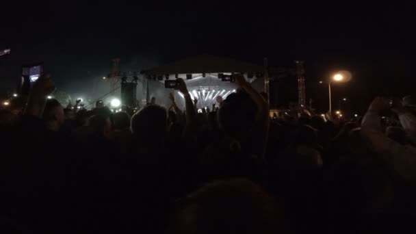 Fanoušci na rockový koncert. Festival pod širým nebem v noci — Stock video