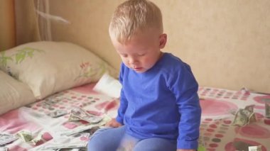 sevimli küçük oğlu yatakta bir doları yağmur altında. Miras kavramı.