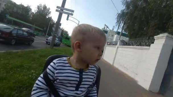 Barn pojke sitter på cykel stol under körning och titta runt — Stockvideo