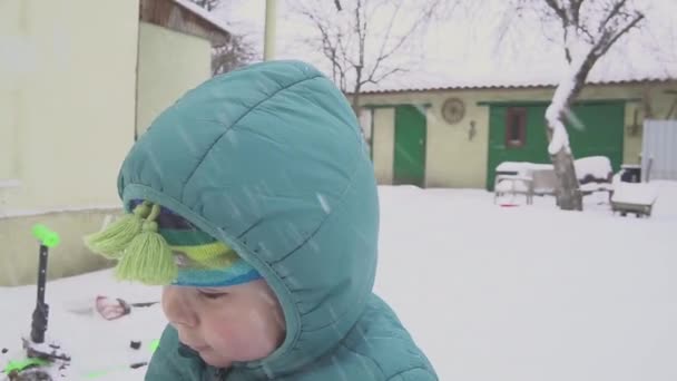 Один год мальчик играет на снегу двор — стоковое видео