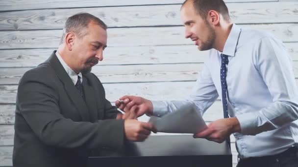 Glimlachend jonge manager overtuigt een client om een contract te ondertekenen. — Stockvideo