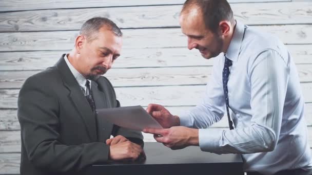 Jovem gerente sorrindo convence um cliente a assinar um contrato . — Vídeo de Stock