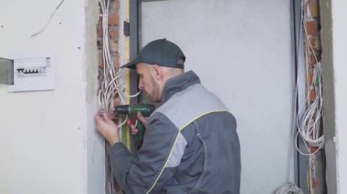 Bir elektrikçi kablo kablo döşeme ekipman ve araçları ile iş yerinde. Tornavida.