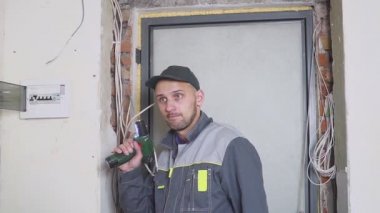 Bir elektrikçi kablo kablo döşeme ekipman ve araçları ile iş yerinde. Tornavida.