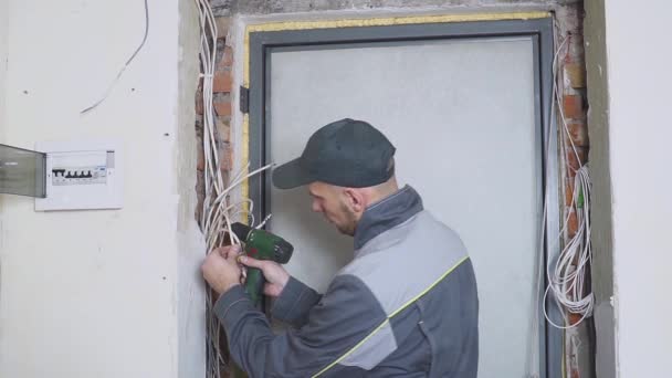 Un electricista en el trabajo tendiendo cable de cableado con equipo y herramientas. Destornillador . — Vídeos de Stock