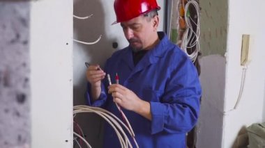 Bir elektrikçi kablo kablo döşeme ekipman ve araçları ile iş yerinde. Tornavida.