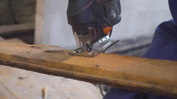 Carpintero trabajando con rompecabezas en la mano. Primer plano de un rompecabezas eléctrico en un árbol . — Vídeo de stock