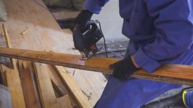 jigsaw ile elinde bir elektrikli testere bir ağaç üzerinde çalışma marangoz.