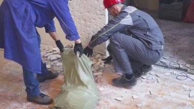 üniformalı iki işçi taşıyan bina enkazı inşaat torba