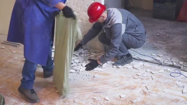 Üniformalı iki işçi taşıyan bina enkazı inşaat torba — Stok video