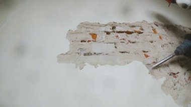 işçi koruyucu kıyafetli alçı duvar yıkan. Punch ve düşen sıva yakın çekim.