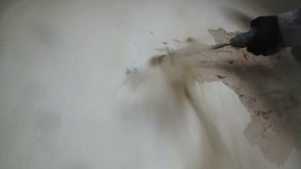 Worker in protective suit demolishes plaster wall. Punch and falling plaster close-up. — Stock Video