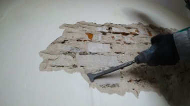 işçi koruyucu kıyafetli alçı duvar yıkan. Punch ve düşen sıva yakın çekim.