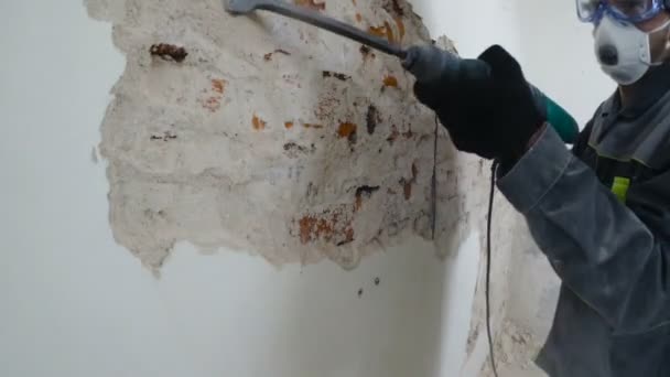 Worker Protective Suit Demolishes Plaster Wall Punch Falling Plaster Close — Stock Video