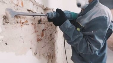 işçi koruyucu kıyafetli alçı duvar yıkan. Kirli, zor iş. Kişisel koruyucu donanım. Kask, maske ve gözlük.