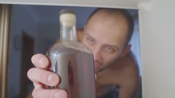 クローゼットの中にボトルから シャツ ドリンク アルコールなしアルコール 家のソファではアルコールの乱用やアルコール依存症の概念で悲しい — ストック動画