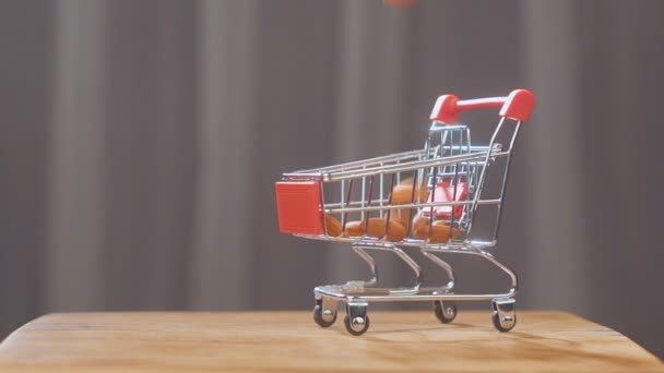 Shoppingvagn från stormarknaden fylld med mandel nötter. mandel nötter falla i stormarknad vagnen. — Stockvideo
