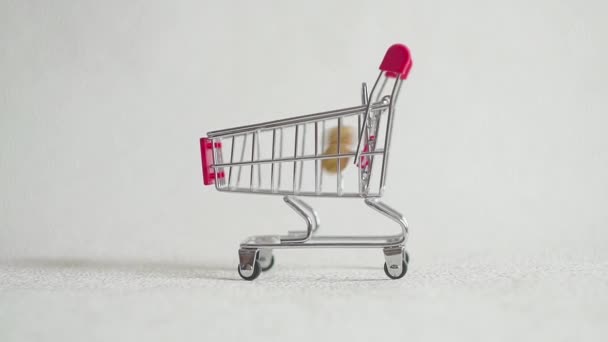 Shoppingvagn från stormarknaden fylld med jordnötter nötter. jordnöt falla i stormarknad kundvagnen. — Stockvideo