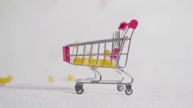 küçük alışveriş sepeti ile makarna. Makarna alışveriş sepeti içine düşmek.