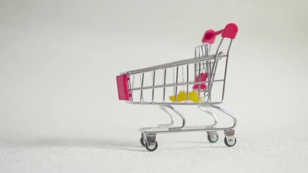 Pequeño carrito de compras con pasta. pasta caer en la cesta de la compra . — Vídeos de Stock