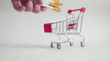 Alışveriş sepeti içinde sigarası. Süpermarket arabası içinde sigarası. Sağlık ve bağımlılık kavramı.